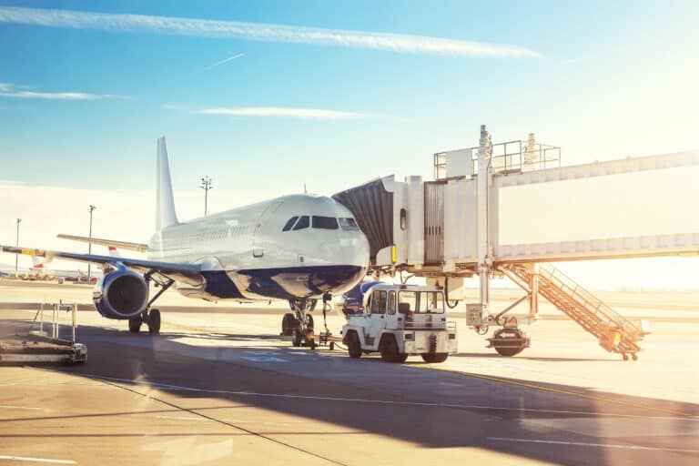 plane at gate at airport with sun