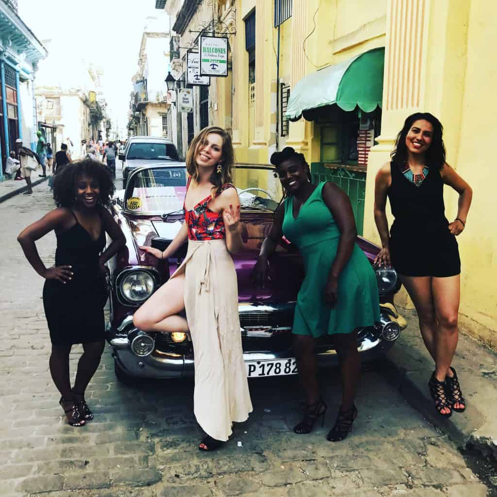 Women in front of Classic car in Cuba