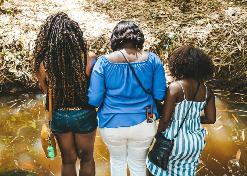 Women standing in the waters of Assin Manso