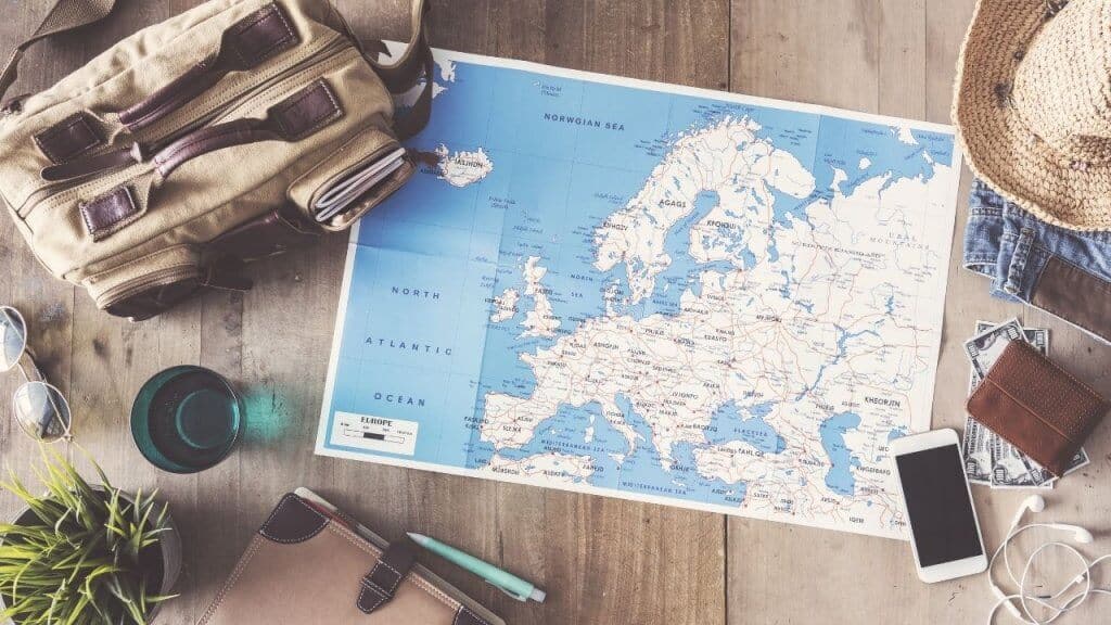 travel map, bag, sunglasses, hat, iphone, and headphones