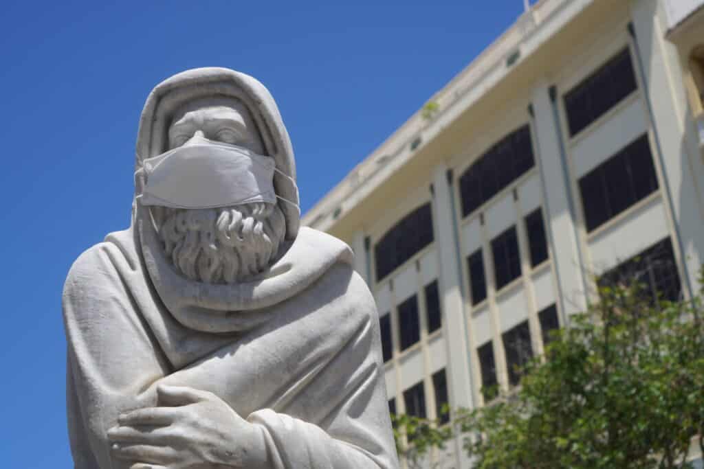 Statue in la plaza de armas with a mask on for COVID.